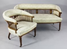 An Edwardian mahogany and marquetry inlaid three piece salon suite, comprising a settee and pair