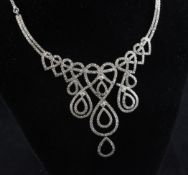 A white gold and diamond set fringe necklace, of scrolling heart design, with a total estimated