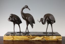 Irenee Rochard. A French Art Deco patinated metal group of three Ibis, on a stepped rectangular