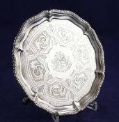 A George III silver waiter, of shaped circular form, with later? engraved decoration and rustic