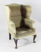 An Irish 18th century style wingback armchair, with scrolling arms, carved cabriole legs and pad