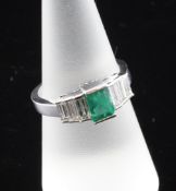 An 18ct white gold, emerald and diamond five stone half hoop ring, the central emerald weighing 1.