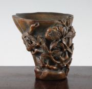 A Chinese bamboo libation cup, carved in high relief and open work with flowering magnolia branches,
