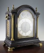 A late Victorian brass mounted ebonised bracket clock, of arched form with silvered Roman chapter