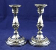 A pair of George IV silver candlesticks, with turned tapering stems and leaf decoration, John &