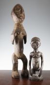 A West African carved hardwood figure of a kneeling female, together with another carved standing