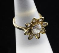 An early 20th century 18ct gold and diamond floral cluster ring, the central cushion cut diamond