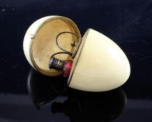 A French ivory egg shaped etui, with engraved gilt metal mounts and a fitted interior including a