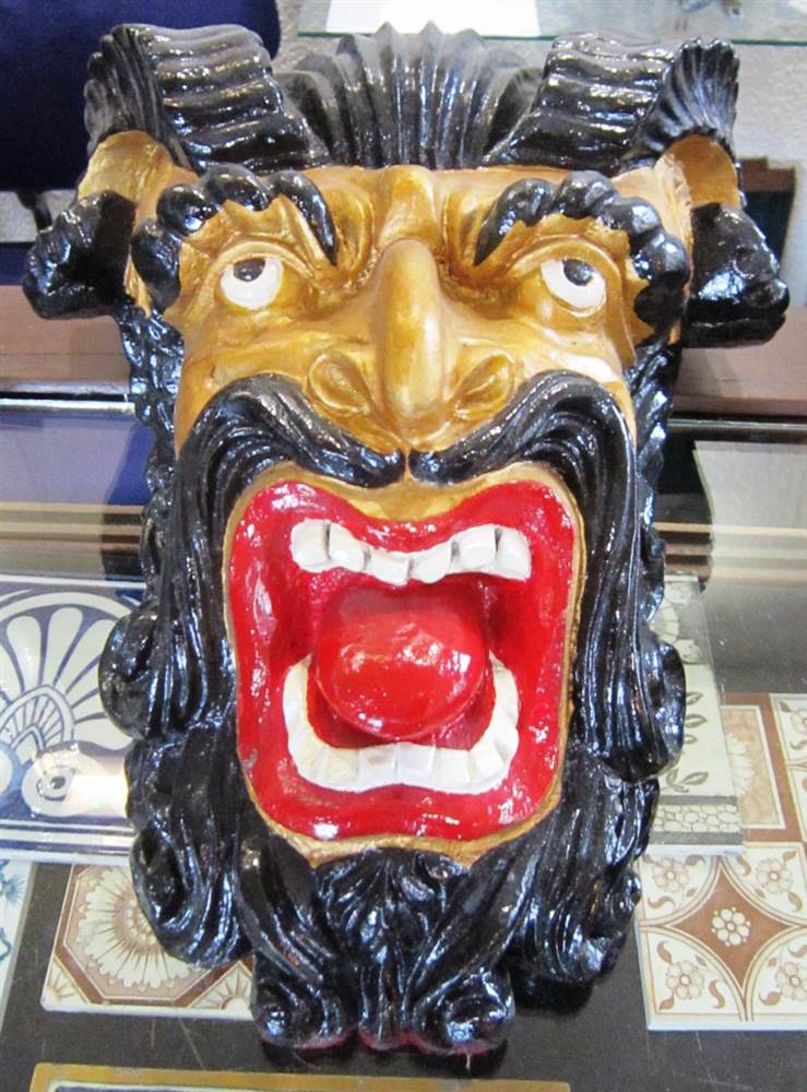 A CARVED & PAINTED WALL MASK in the form of a bearded grotesque, 37cm high.