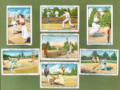A collection of framed cigarette cards depicting tennis, including Ensenanza Los Juegos Law