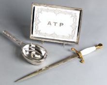 An Asprey spoon rest designed as a tennis racquet,
heavy silvered metal marked ASPREY PLC,