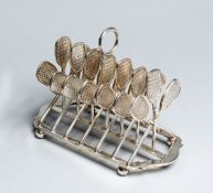 A silver plated toast rack with dividers designed as flat-topped tennis racquets circa 1890s,
with