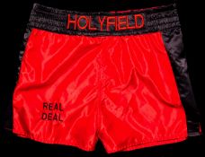 A certificated pair of Evander Holyfield boxing trunks,
red satin with black trim, inscribed