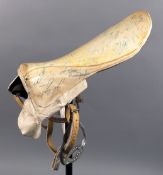 A 1970s racing saddle signed by jockeys.
the white, lightweight saddle profusely signed in pen,
