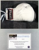 A Mike Tyson signed boxing glove, a white Title glove signed in black marker pen, mounted in a glass