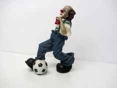 A ceramic figure of a clown footballer,
height 20cm., 8in.; sold together with a plastic figure of a