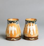 A matching pair of Doulton Lambeth stoneware beakers featuring cyclists circa 1900,
thee vignettes
