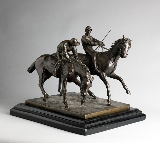 A 19th century bronze group of two racehorses and jockeys raring to go at the start of a race,