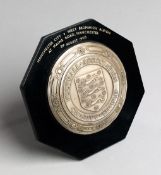 A miniature silver replica of the F.A. Charity Shield,
mounted on an octagonal bakelite backboard