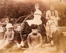 A rare and unusual photograph of lawn tennis players seated on and around a velocipede circa 1880s,