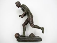 A spelter figure of a footballer, signed Fugere, modelled running in possession of the ball, 33cm.,