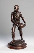 A French bronze sculpture of a rugby player, signed to the base G. DEMANGE, the young man well