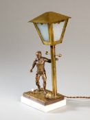 A table lamp designed with a brass footballer set on a marble base, the lamp post with detachable