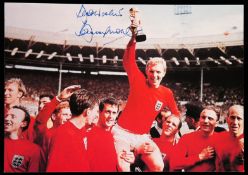 A signed colour photograph of Bobby Moore,
seen holding the Jules Rimet Cup aloft at Wembley in