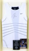 A Michael Johnson signed athletics vest,
signature in black marker pen, mounted in a frame under