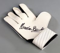 A goalkeeper's glove signed by Gordon Banks,
& black & white Umbro glove signed in black marker pen