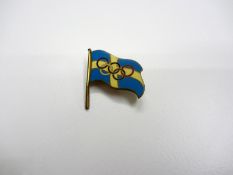 A Swedish Olympic pin,
enamelled with the Swedish national flag and Olympic Rings

Provenance: