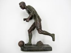 A spelter figure of a footballer,
signed Fugere, modelled running in possession of the ball,