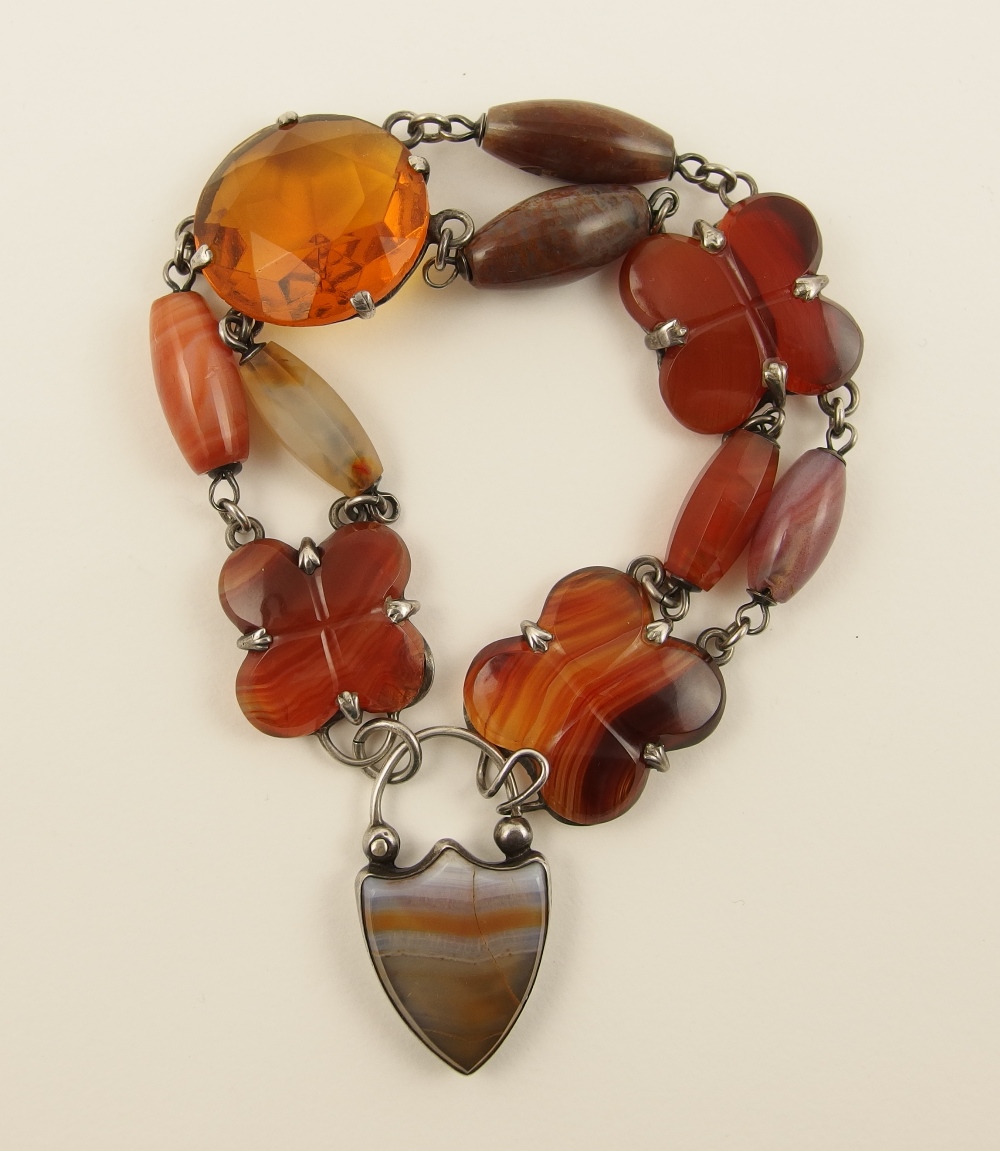A Scottish agate bracelet consisting of trefoil carved plaques and carved barrel shaped agate beads,