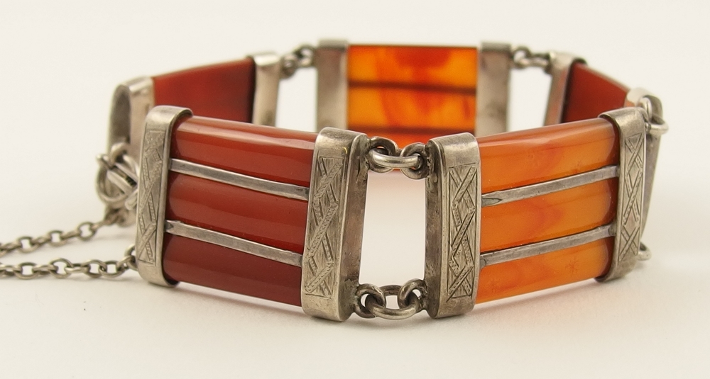 A Scottish silver agate bracelet formed of five ribbed panels of orange translucent and opaque