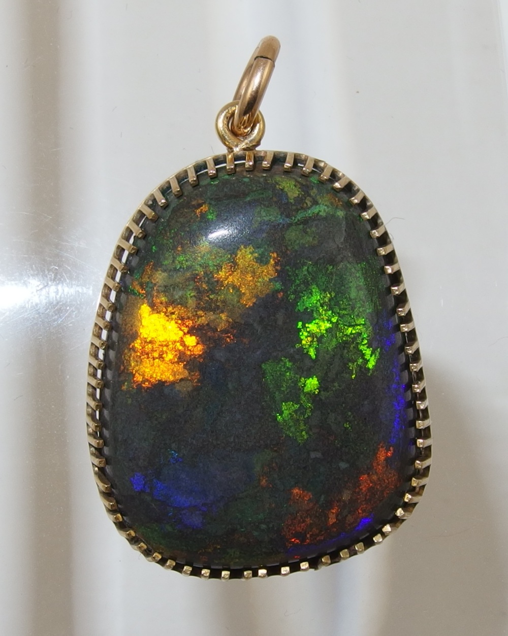 An Andamooka opal matrix pendant in yellow metal galleried mount, approx size of opal 28mm x 22mm x