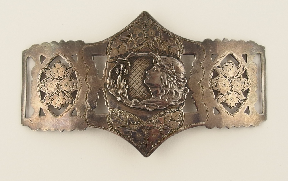 A silver Art Nouveau buckle with a centrally mounted plaque of a maidens head, with swirling hair