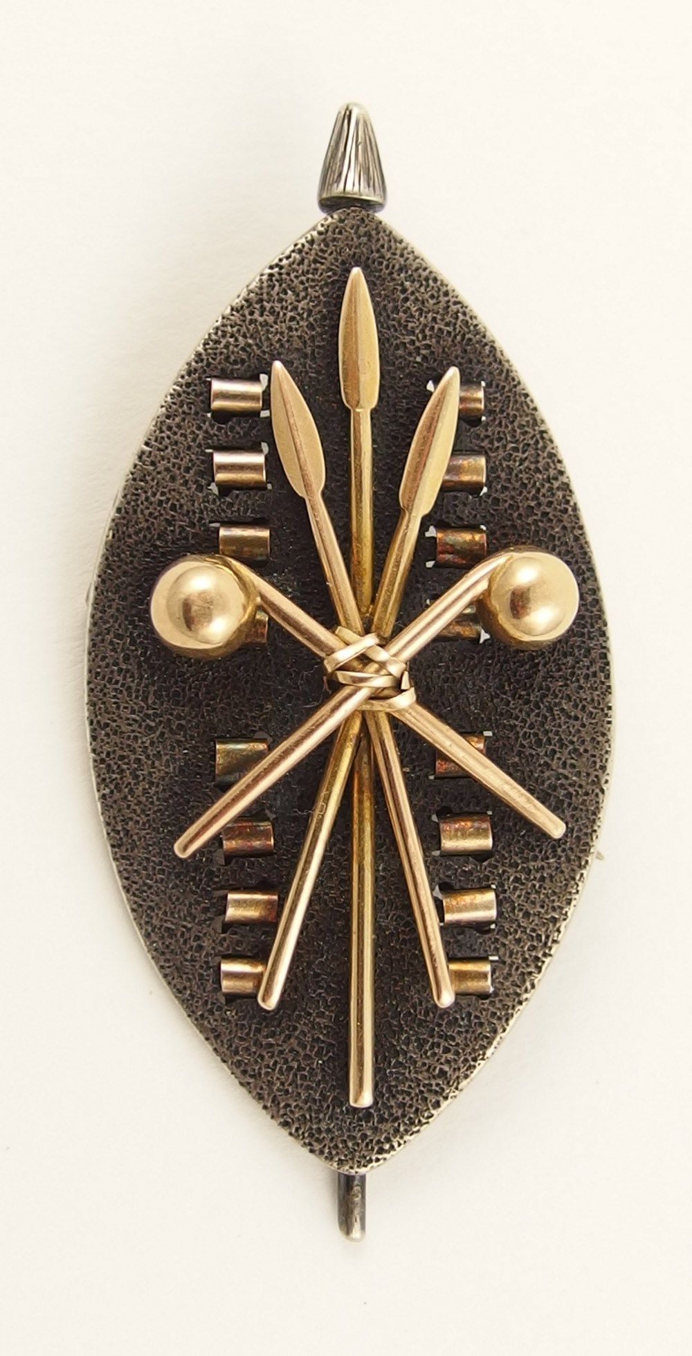 A Zulu war sweetheart brooch shield in oxidized white metal with textured ground, with applied