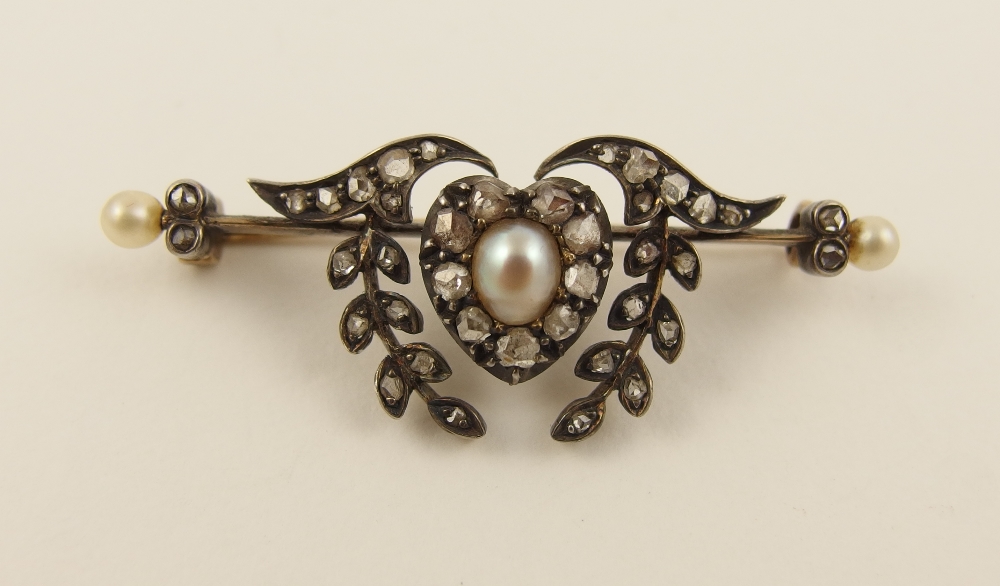 A Victorian diamond and pearl brooch in yellow and white metal with central heart shaped motif set