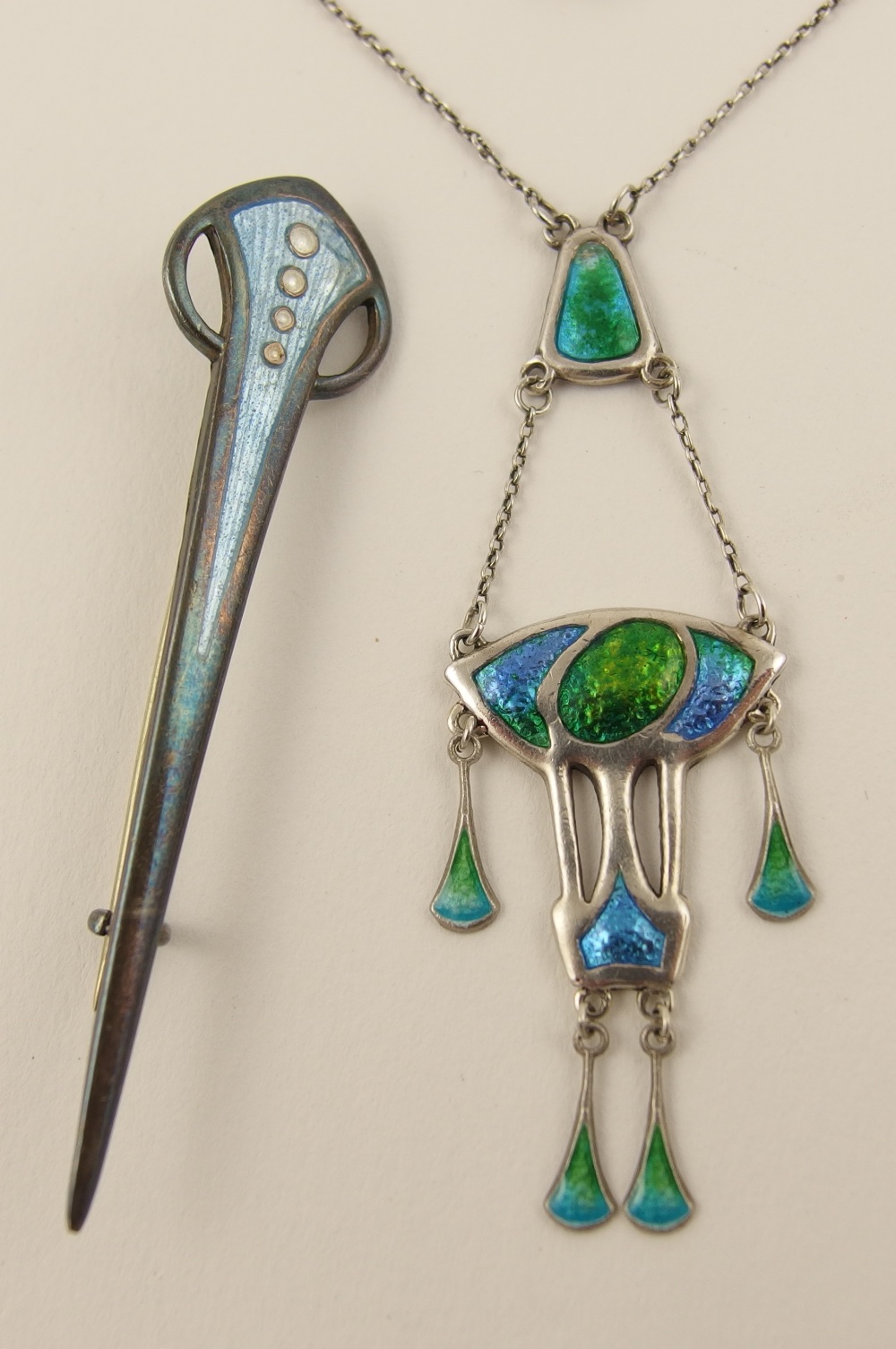 A Charles Horner pendant enamelled in blues and greens the pendant suspended from a central