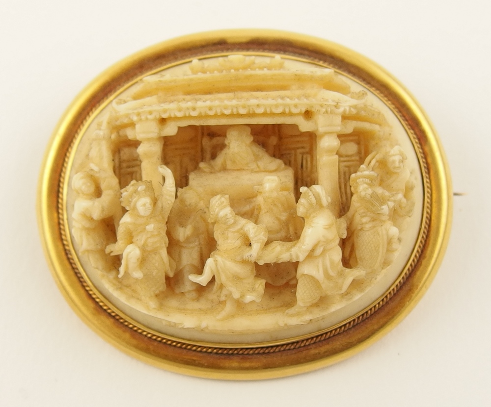 A 19th Century Chinese Export ivory brooch finely carved with a court scene, mounted in