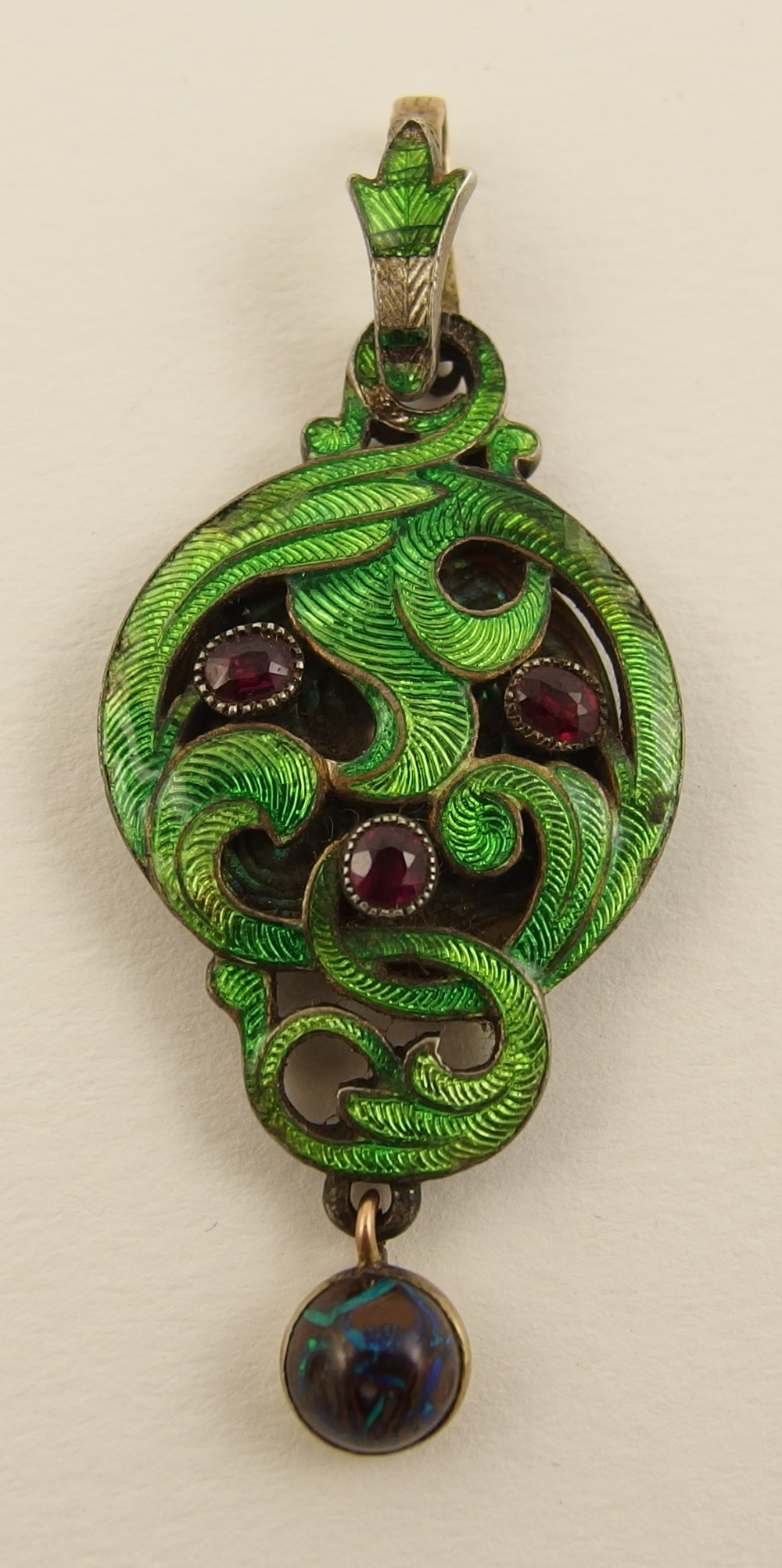 A Child & Child pendant with hand engraved ground of swirling leaves enamelled in green, set with