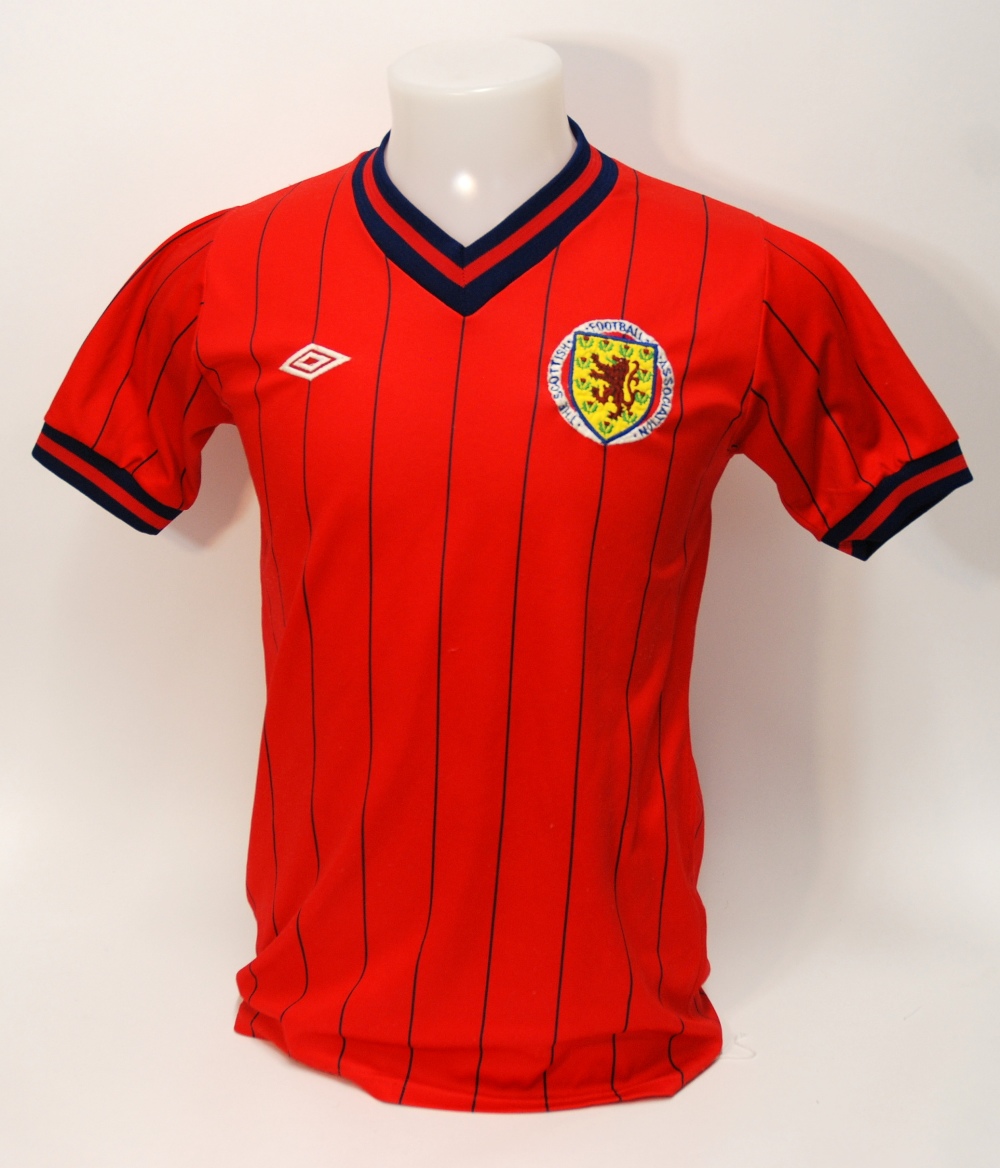 A red Scotland International short-sleeved shirt No.7, with v-neck collar and embroidered badge,