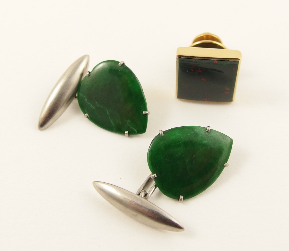 A pair of green hardstone cufflinks of thin leaf shape of a deep green colour mounted in a