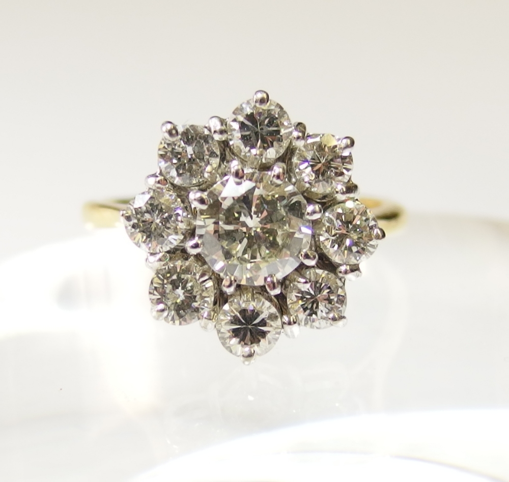 A diamond flower ring in 18ct yellow and white gold the central diamond of approximately 0.72cts