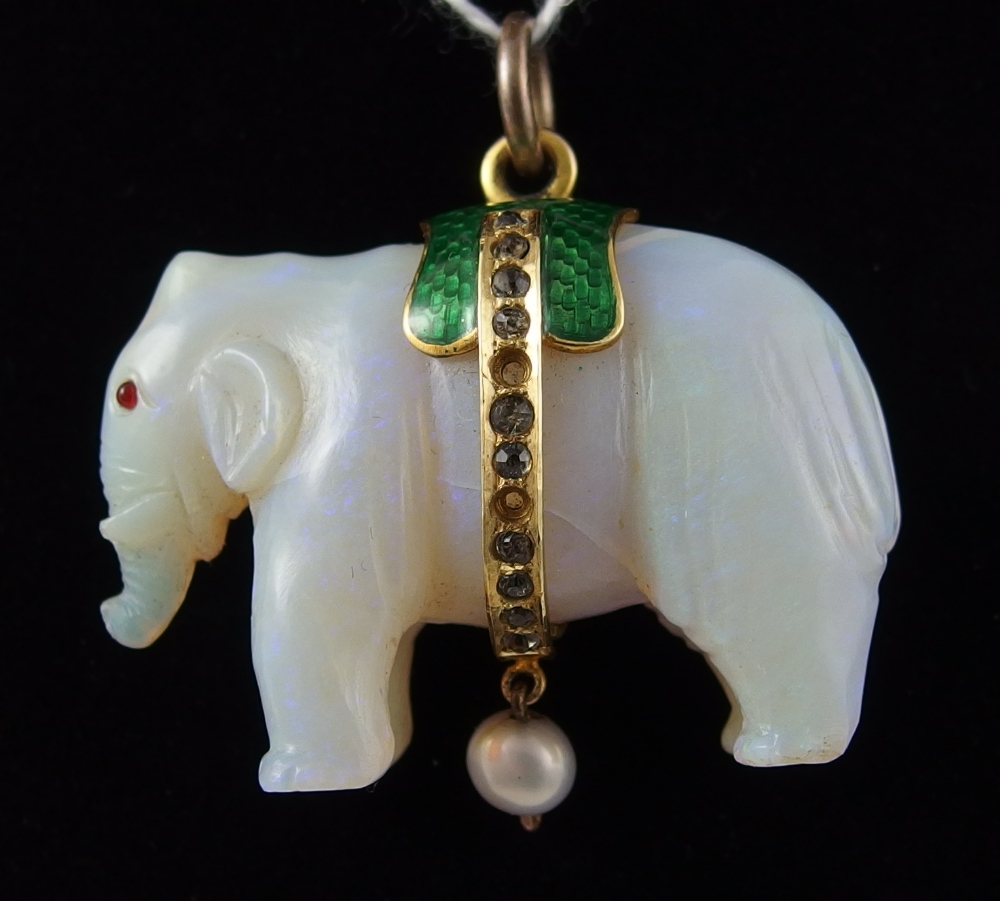 An elephant opal pendant carved from a single piece of white opal the Asian elephant has red gem set