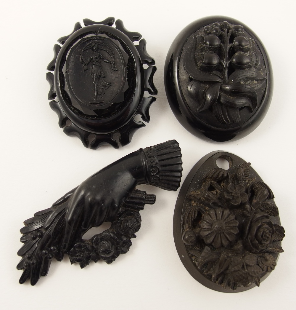 Four Victorian mourning brooches in a selection of materials, jet, glass and vulcanite.