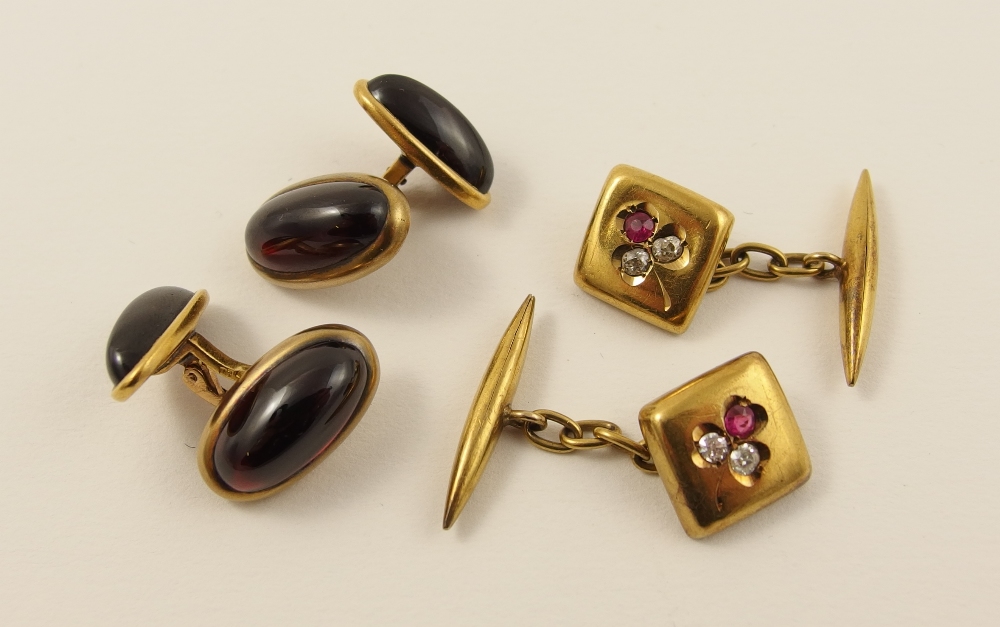 Two pairs of cufflinks a pair in 14ct set with oval cabouchon garnets, together with a pair of