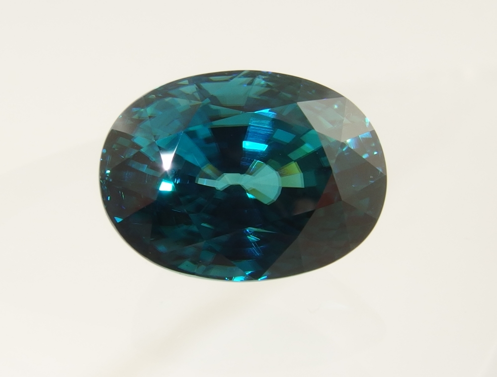 A substantial zircon gem the colour is deep teal green, oval brilliant cut, dimensions 18mm x 13mm x
