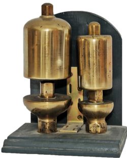 GWR brass Locomotive Whistles, a pair mounted on  a wooden board for display. The smaller `
