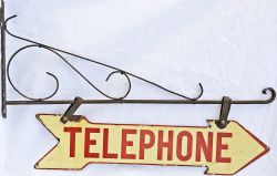 Enamel `TELEPHONE` sign on its original bracket measuring 18" x 26", red lettering on buff ground,